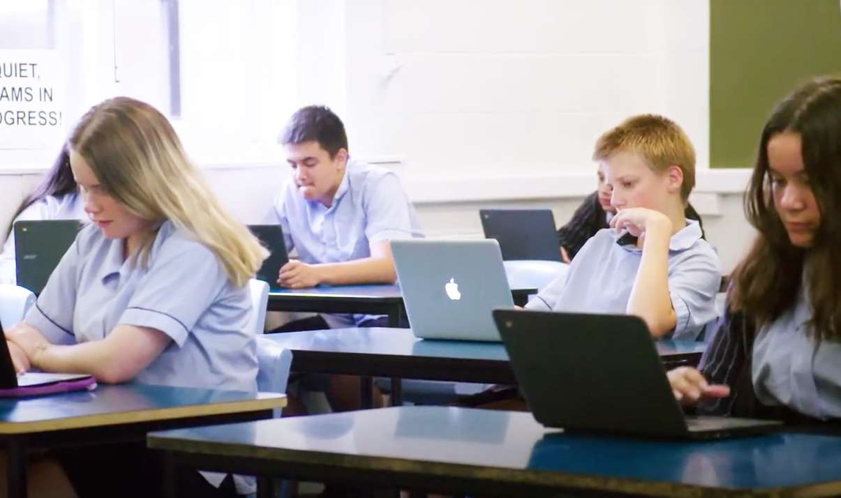 A group of students using laptops in a classroom