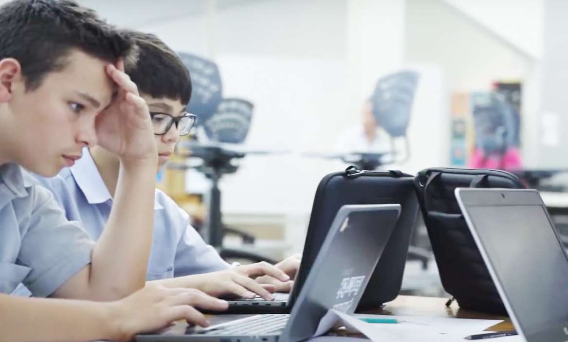 Two boys working on laptops in the classroom