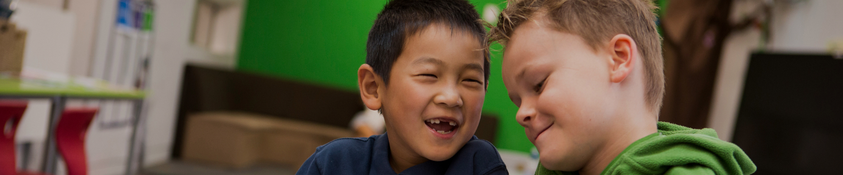 Two young boys laughing while at school