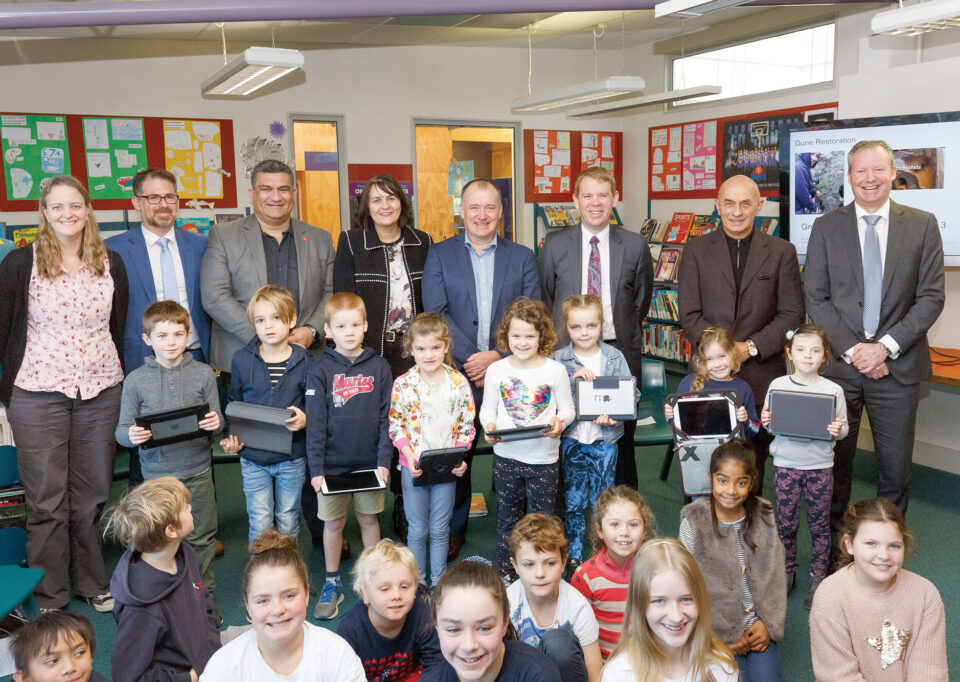 Then Minister of Education, Chris Hipkins and other partners with a group of students in a classroom