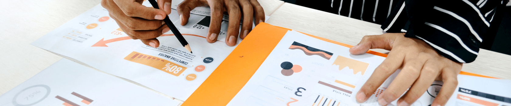 Two people working on some graphs on a desk