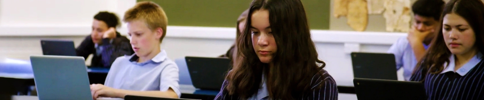 Group of students sitting at their desks using laptops