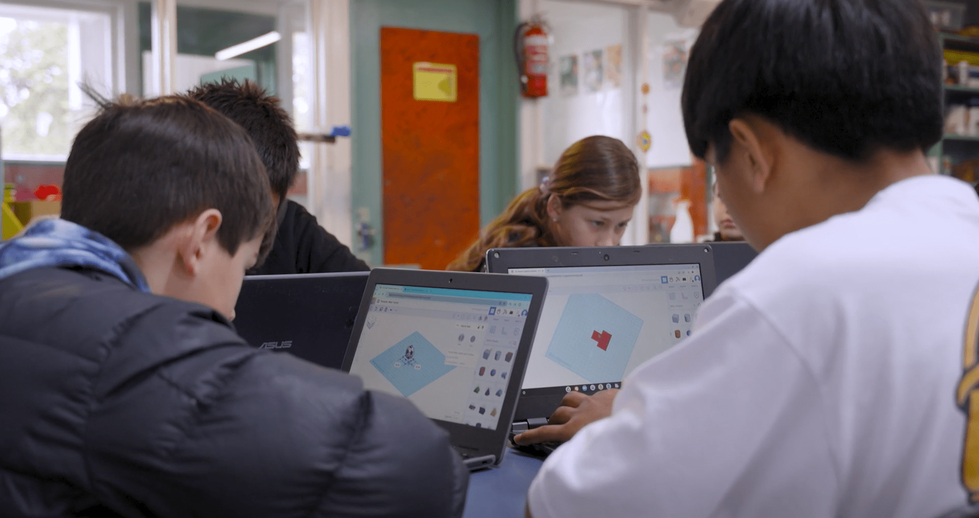 Teacher with student in class learning on laptop
