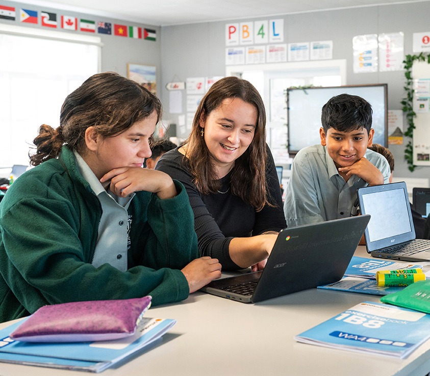 Teacher on laptop with girl and boy