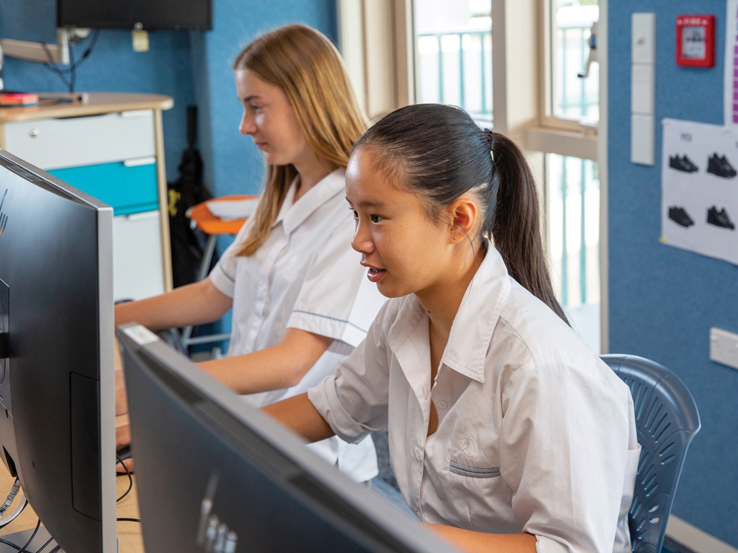 Two teenage students working together on tablet